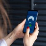 Kobieta trzyma smartfon z włączoną aplikacją VPN, dba o prywatność danych