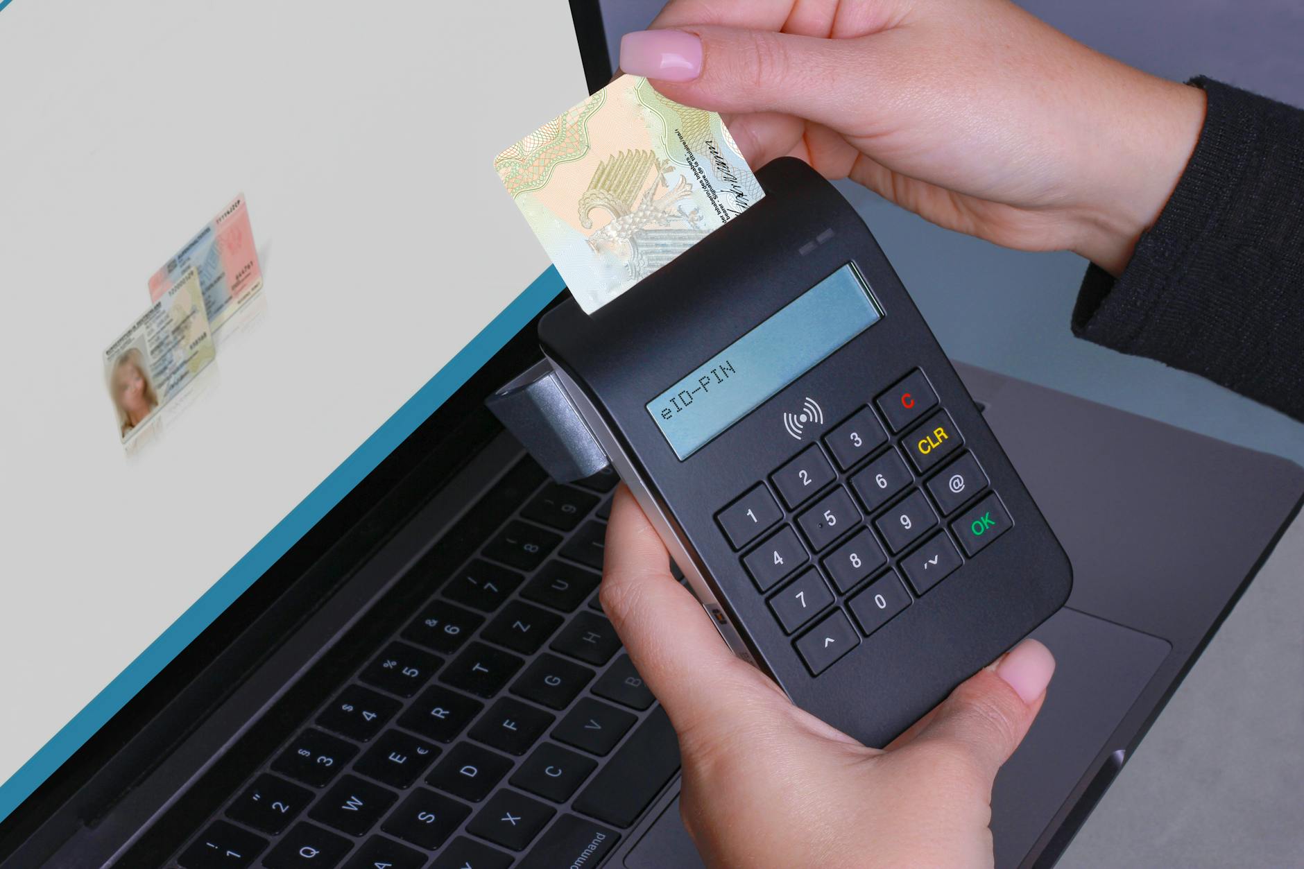 Osoba przykłada bezdotykową kartę do laptopa w celu weryfikacji tożsamości