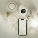 Smartfon i rozłożone na białym tle urządzenia inteligentnego domu