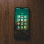 Smartfon z aplikacjami Google leżący na drewnianym stole