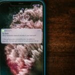 Smartfon na stole wyświetlający powiadomienie z alertem bankowym