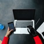 Osoba z protezą dłoni korzysta równocześnie z laptopa, smartfona i tabletu