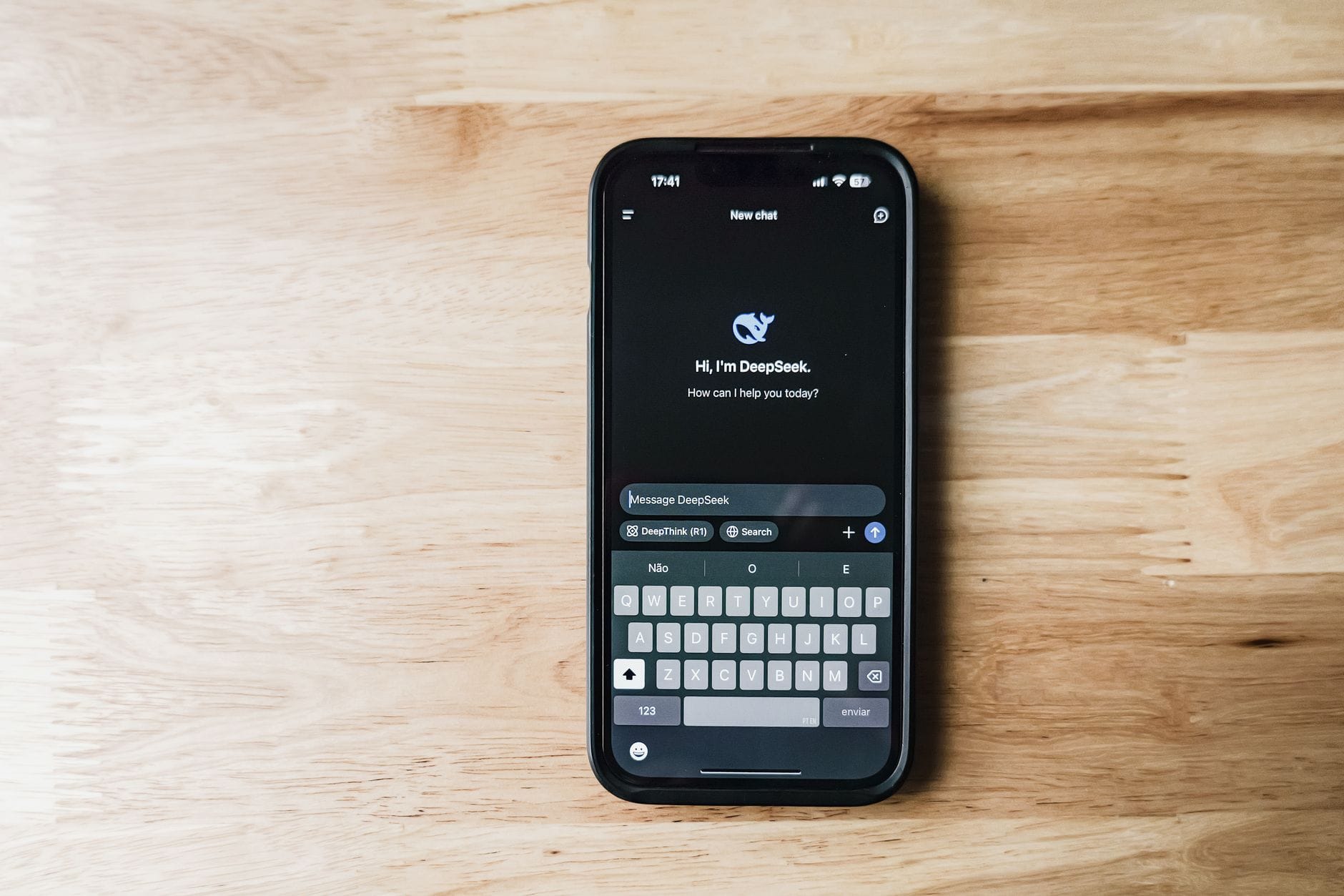 Smartfon na drewnianym stole z interfejsem chatbota AI DeepSeek