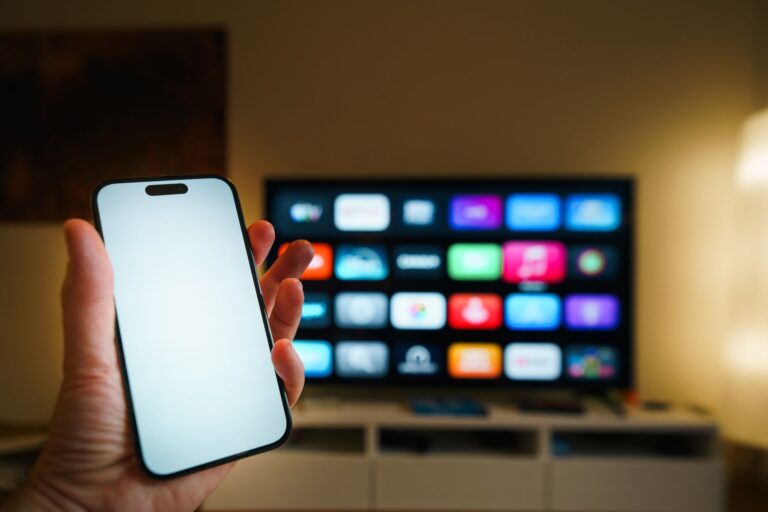Smartfon na tle telewizora z aplikacjami w przytulnym salonie